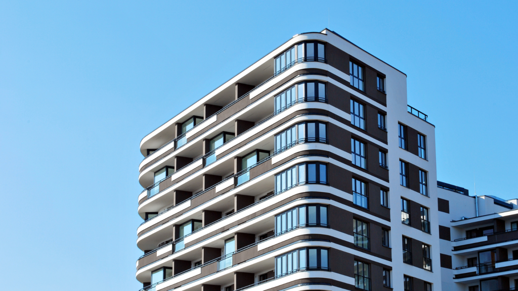 Imagem de prádio com vários andares com o céu azul ao fundo