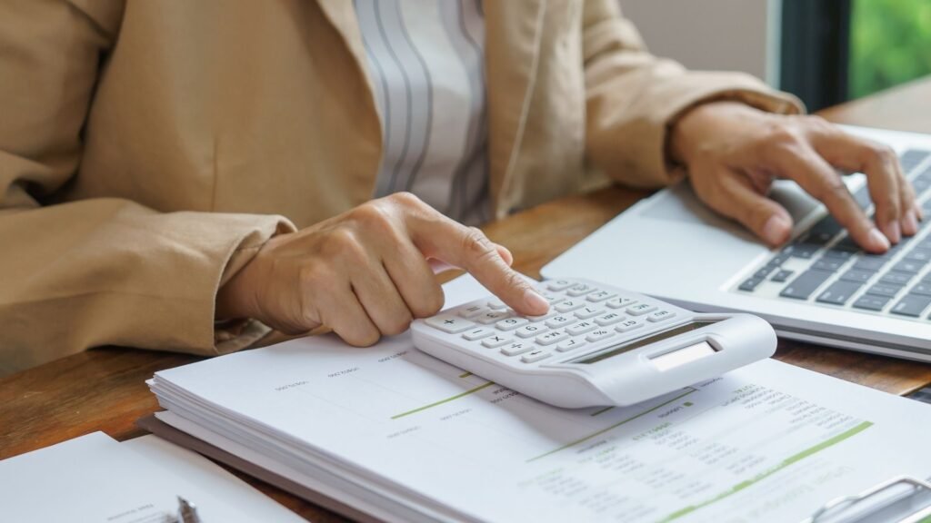 mãos manuseiam calculadora e notebook