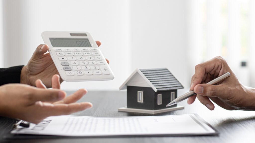 Mãos em uma mesa com papeis e calculadora